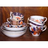 Five early 19th century English porcelain cups and saucers, each decorated in the Imari palette,
