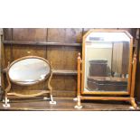 An arched top swing dressing mirror, in stained chamfered frame, 23" wide, and a Georgian style oval