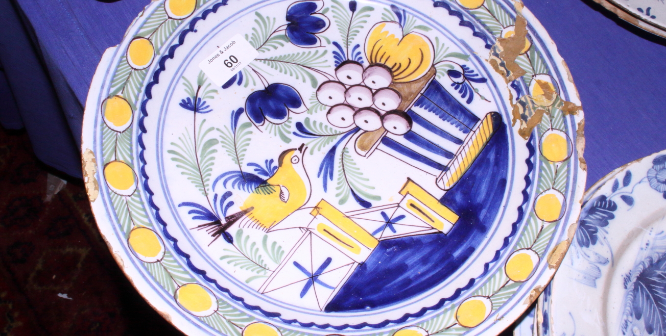 A Delft pottery blue and white charger decorated with sprays of flowers within a cross hatched