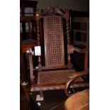 A carved oak folding steamer chair with cane seat and back panels and eagle crest