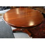 A 20th century mahogany circular dining table, on triform base terminating in scroll feet, 48"