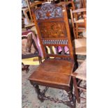 A 19th century carved oak and inlaid hall chair with panel seat and back, on turned and