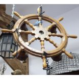 A four-light ship's wheel pendant centre light and a ship in a glass bottle