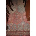 A Persian "garden" design rug with octagonal panels of trees and birds in shades of rust, blue,