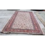 A Persian design bordered carpet, beige field decorated scrolling foliage, 180" x 80"