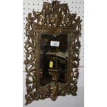 A 19th century brass framed bevelled glass mirror, cast with pierced scroll decoration, 17" x 10"