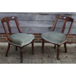 A pair of Victorian mahogany standard chairs with bucket shaped backs and stuffed over seats,