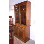 An Edwardian oak bookcase, the upper section enclosed two glazed panel doors over two drawers and