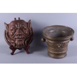 A 19th century, possibly earlier, cast brass two-handled mortar, decorated with heads of Bacchus,