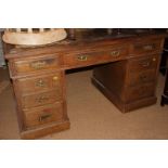 A late 19th century oak double pedestal desk, fitted nine drawers with tooled lined top (for