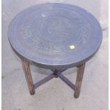 A Benares brass tray top table, on folding brass base