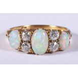 An 18ct gold, opal and diamond seven stone dress ring, size N