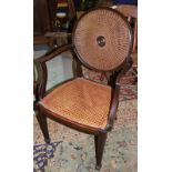 An early 20th century mahogany framed open armchair with cane back and seat, on spade supports