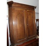 A late Georgian quarter cut oak corner hanging cupboard enclosed two inlaid panel doors with