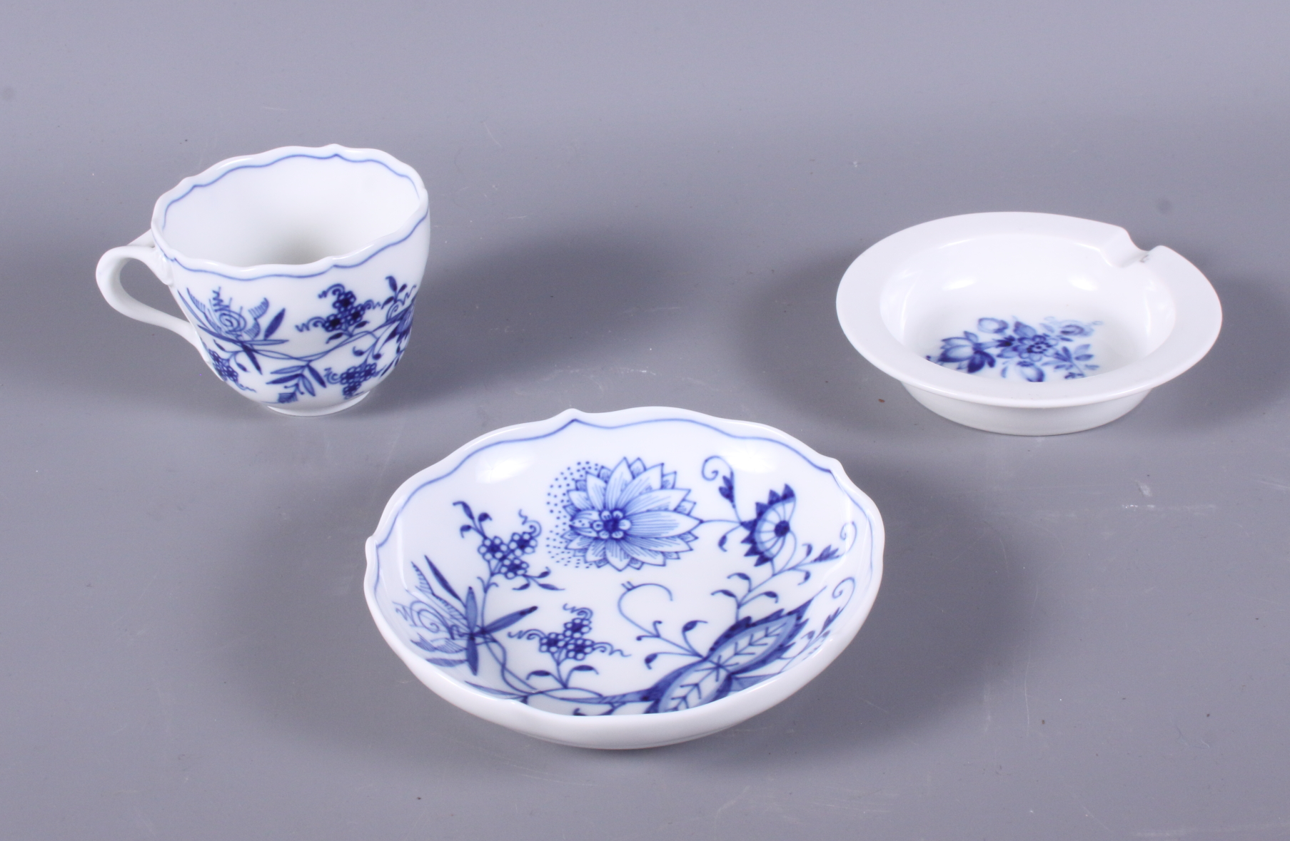 A Meissen blue and white decorated coffee cup, a similar saucer and ashtray