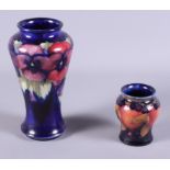 An early 20th century Moorcroft pottery Pansy vase on a midnight blue ground, 7" high, together with