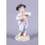 A late 19th century Meissen porcelain figure, Boy Playing a Flute, on a low relief base with gilt