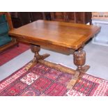 An oak draw leaf dining table of 17th century design, on turned and carved cup and cover supports