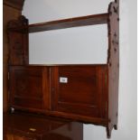 A late Victorian mahogany hanging two door wall shelf