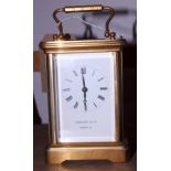 A mid 20th century Garrard & Co brass four-glass carriage clock with swing handle, white dial with