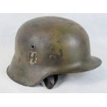 A German WWII SS helmet with decals and leather lining.