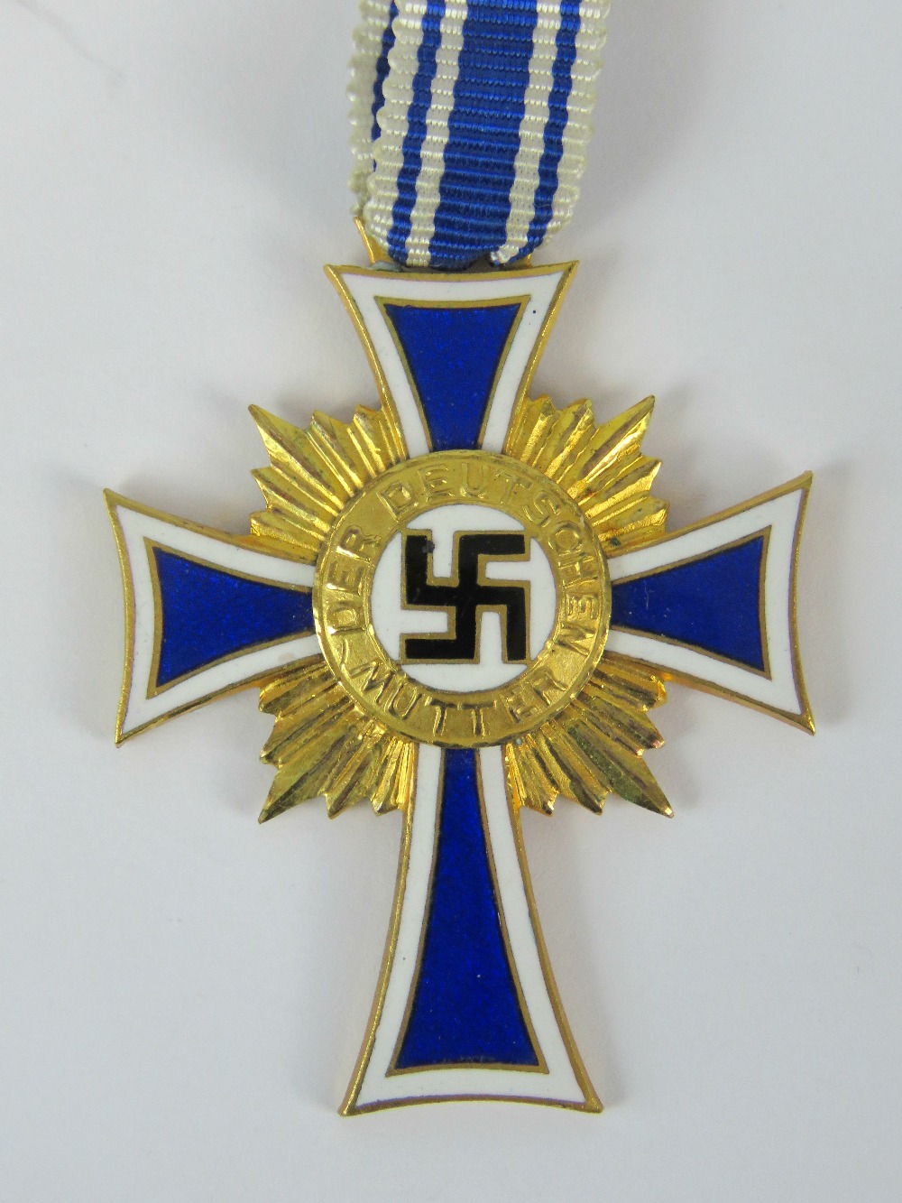 A Nazi German, Mothers' cross (4.2cm long)with blue and white ribbon, inscribed verso "16.