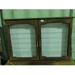 A glazed mahogany wall hanging display cabinet; with two banks of six glass shelves; 92cm wide.