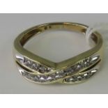 A 9ct gold and diamond ring, crossover yellow metal shank set with eighteen diamonds,