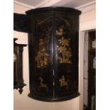 A George III Japanned barrel-fronted hanging corner cabinet decorated and with gilded hunting