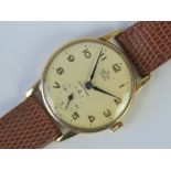 A 9ct gold Smiths De Luxe manual wristwatch, cream dial with yellow metal Arabic numerals,