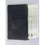A vintage gentlemans black leather wallet containing four vintage £1 notes within c1950s.