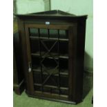 An early 19thC oak hanging corner cabinet with glazed door.