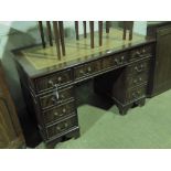 A good reproduction pedestal kneehole desk having tooled brown leather writing surface,