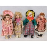 Three bisque headed dolls with glass eyes and a clown doll; one doll with spectacles;