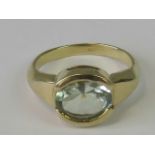 A 9ct gold ring with central oval cut quartz of slight green hue, approx 2.