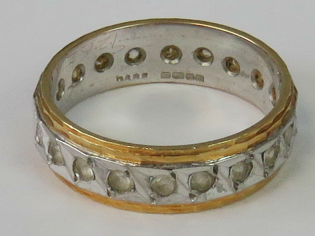 An 18ct white and yellow gold eternity ring set with white stones, size J-K, 4.