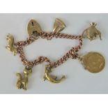 A 9ct rose gold curb link charm bracelet with six charms including a 22ct gold 1908 half sovereign