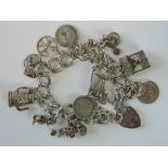 A silver charm bracelet with hallmarked heart padlock clasp, eleven charms including 'Donald Duck',