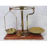 A set of early 20th century apothecary scales mahogany base and brass fittings together with three