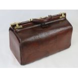 A vintage brown leather Gladstone bag having single handle and brass fittings.