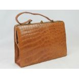 A vintage tan leather crocodile skin handbag having single loop handle and brass fittings.