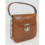 A vintage tan leather crocodile skin handbag having single loop handle and brass fittings.