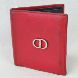 Christian Dior; a vintage red leather wallet with gilded insignia and stamped Christian Dior Paris,