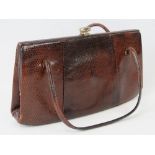 A vintage brown leather crocodile skin handbag having two loop handles and gilded fittings.