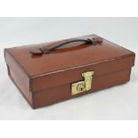 A tan leather ladies travelling case with brass lock and pink suede lining, 28.5 x 19 x 8cm.