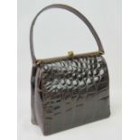 A vintage brown leather crocodile skin handbag having single loop handle and brass fittings.