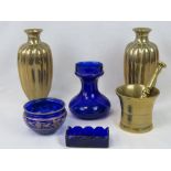 A pair of brass vases with relief designed dragons to each base together with a brass pestle and