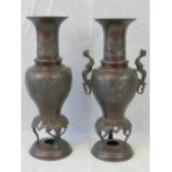 A pair of Oriental bronzed vases, one with handles deficient. Each 35cm high.