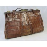 A vintage brown leather crocodile skin handbag having twin loop handles and brass fittings.
