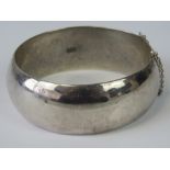 A silver hinged cuff bangle, 2.5cm wide, stamped 925, complete with guard chain, 43.